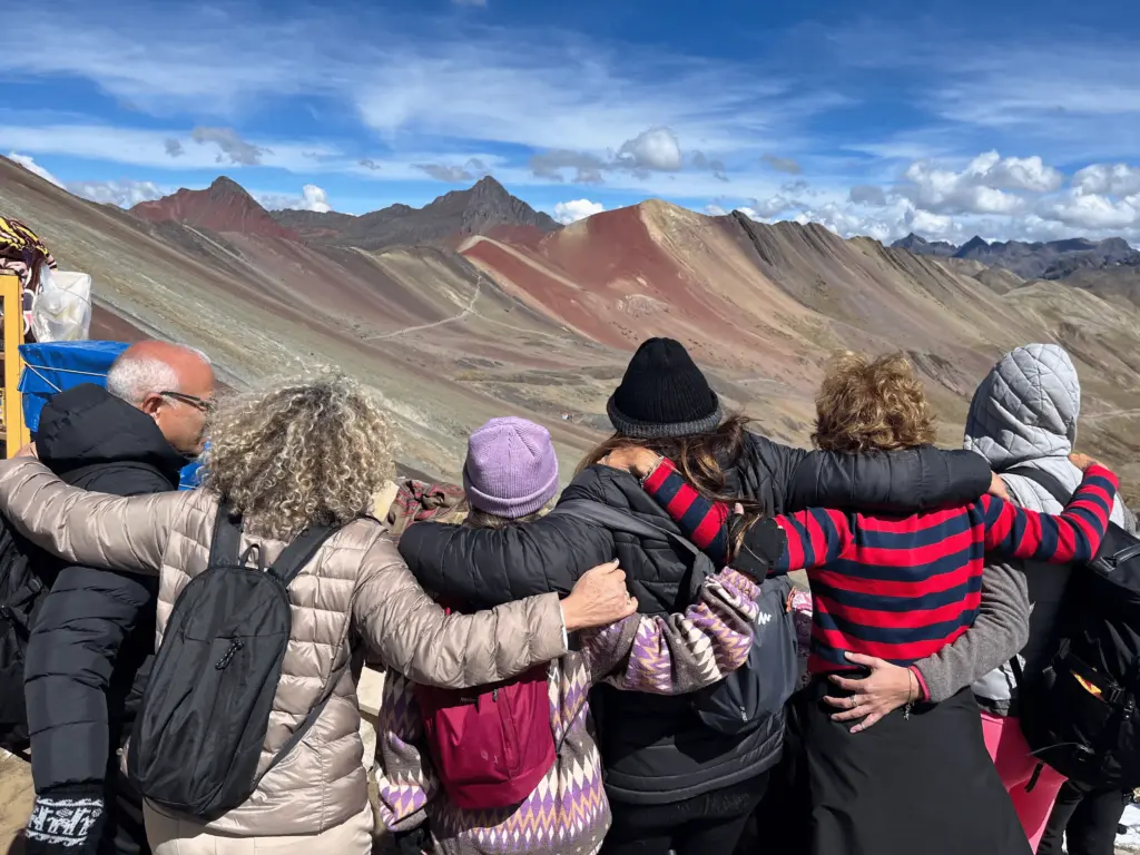 Grupo de turistas contemplando a Montanha Colorida no Peru durante viagem organizada pela KG VIAGENS.