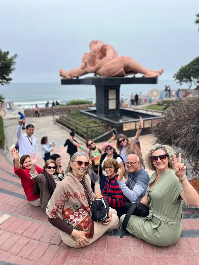 Grupo de turistas da KG Viagens sorrindo em frente à escultura El Beso no Parque del Amor, Miraflores, Lima - Peru